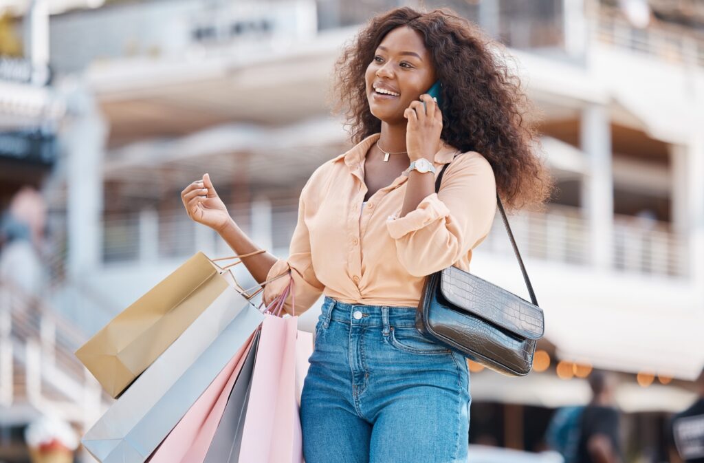 Shopping, fashion bag and phone call for black woman on 5g communication about retail spree or sale